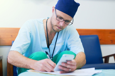 Mannlig lege fyller ut papirskjema. Foto: Colourbox.