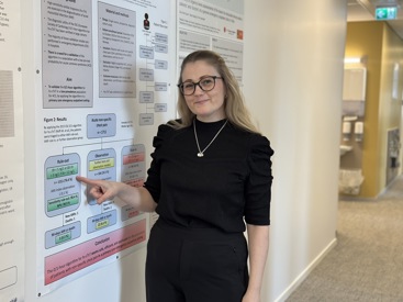  ph.d. Tonje R. Johannessen, forsker og legeskiftleder ved Allmennlegevakten i Oslo peker på poster i korridoren