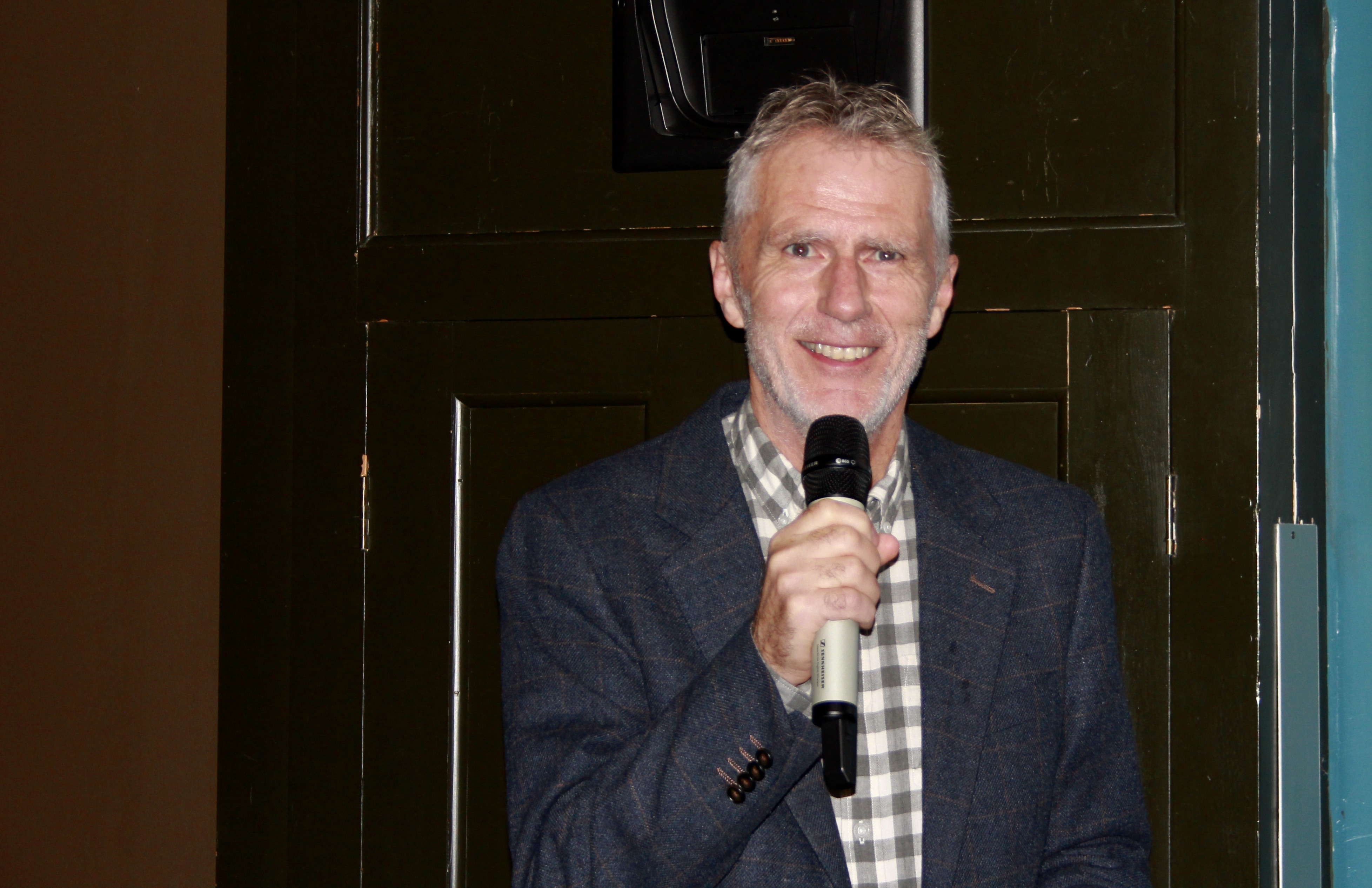 Gr&aring;h&aring;ret mann med mikrofon i h&aring;nden