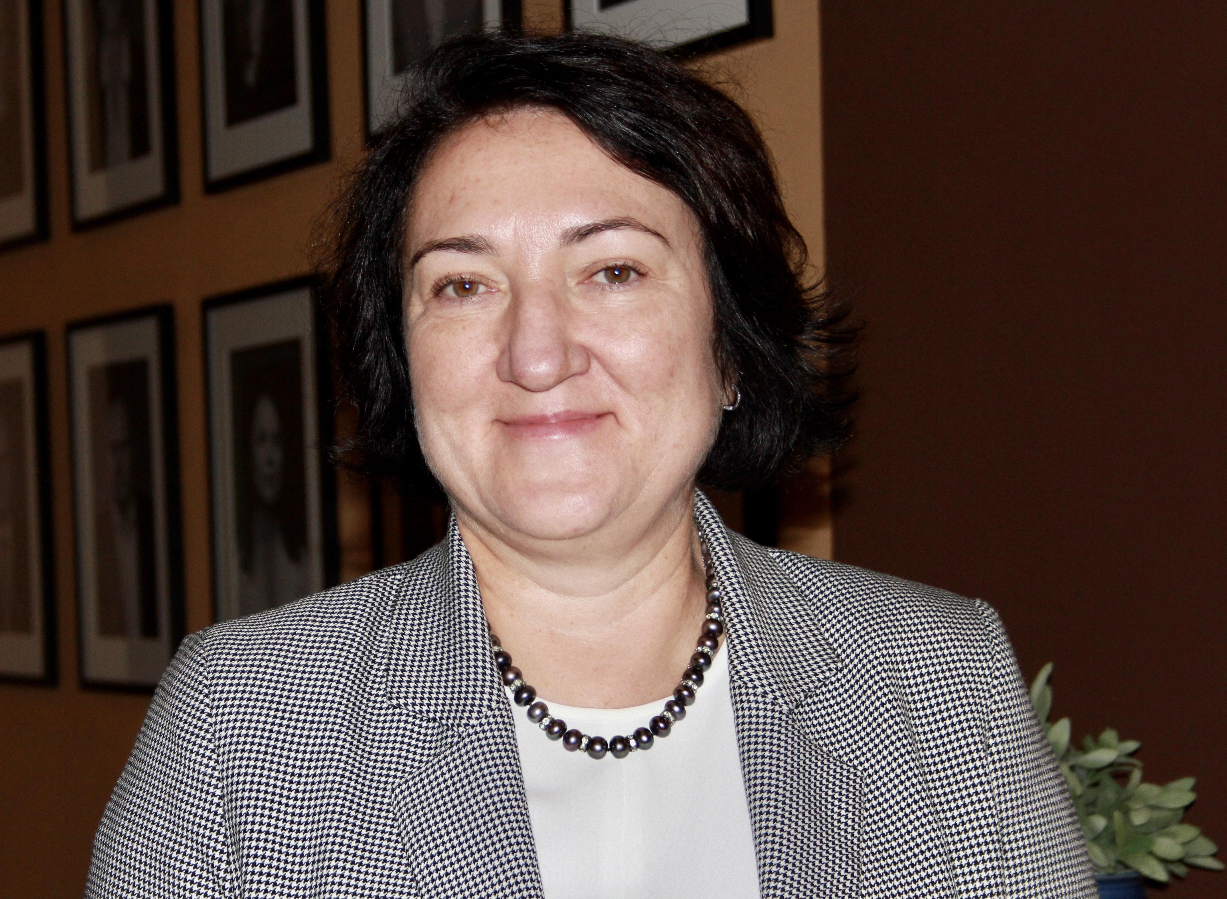 En voksen smilende kvinne med svart h&aring;r