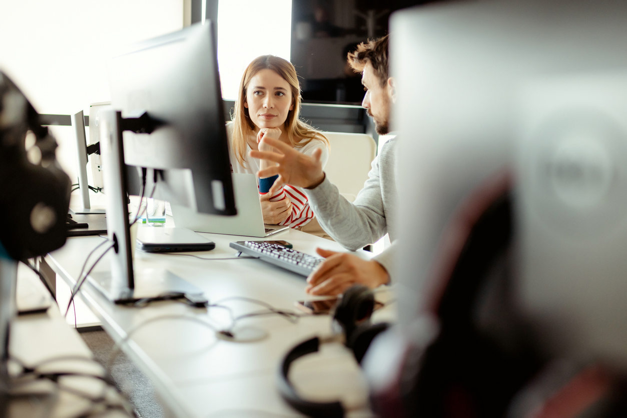 Bilde av dame og mann ved en PC. Mannen forklarer damen noe. istockphoto