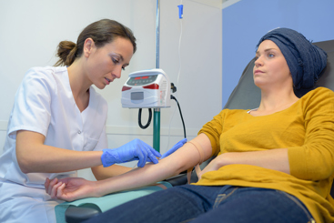 Kvinnelig lege vasker setter et veneflon på kvinnelig pasient. Foto: Colourbox.