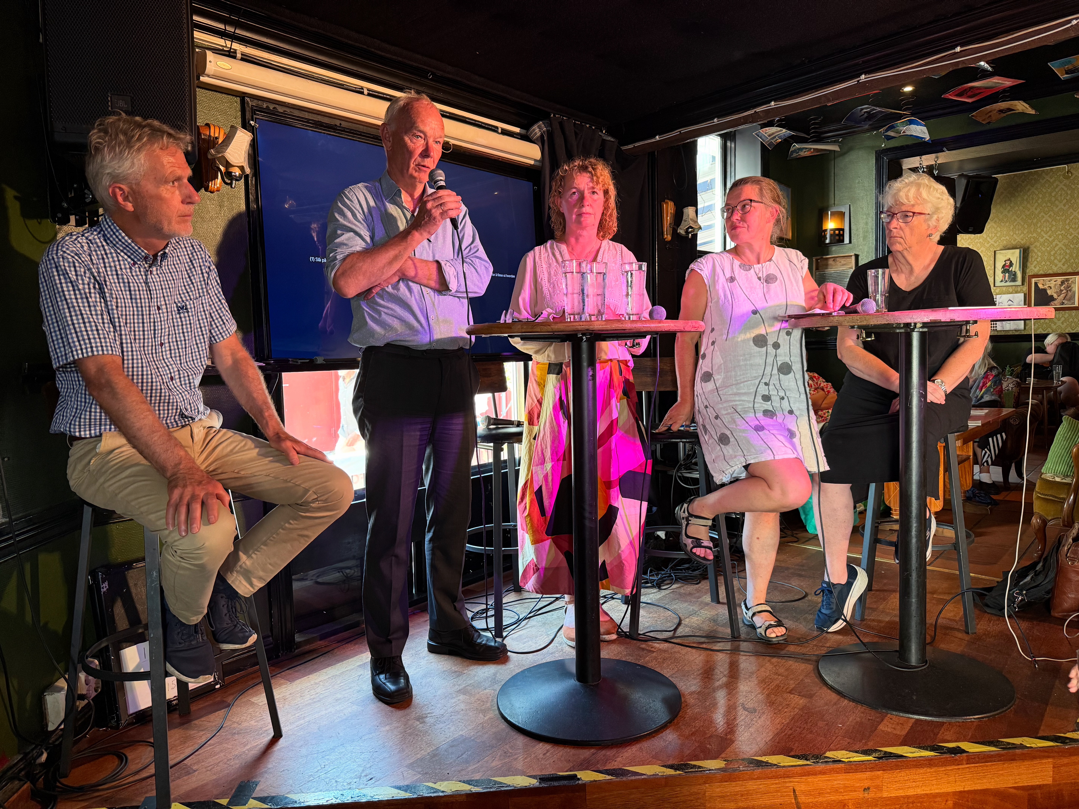 To menn og tre kvinner p&aring; en scene i en debatt.