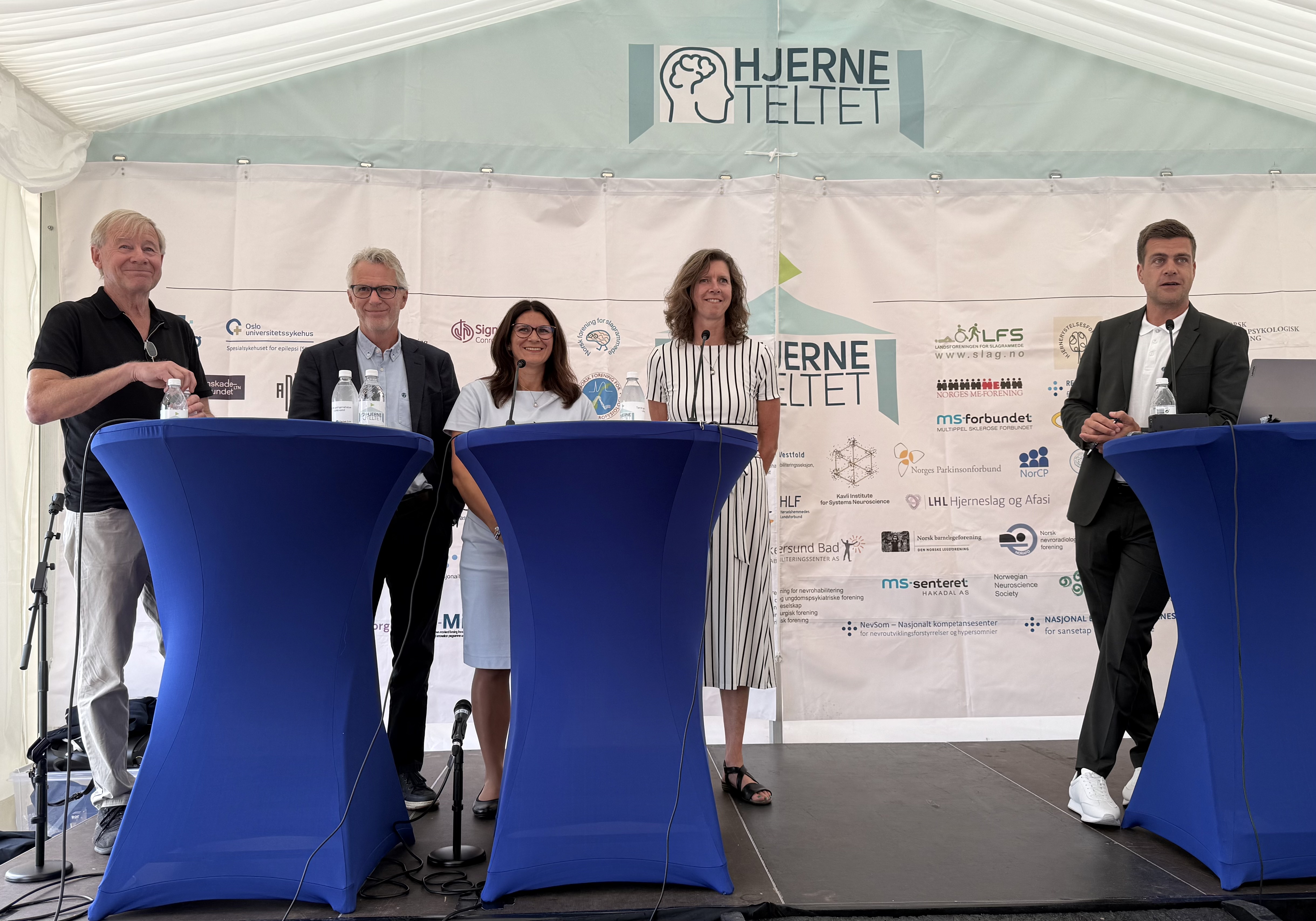 Mennesker p&aring; en scene i en debatt.