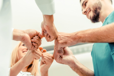 Leger som holder ut knyttnever i en ring. Foto: Istockphoto.com/NanoStockk