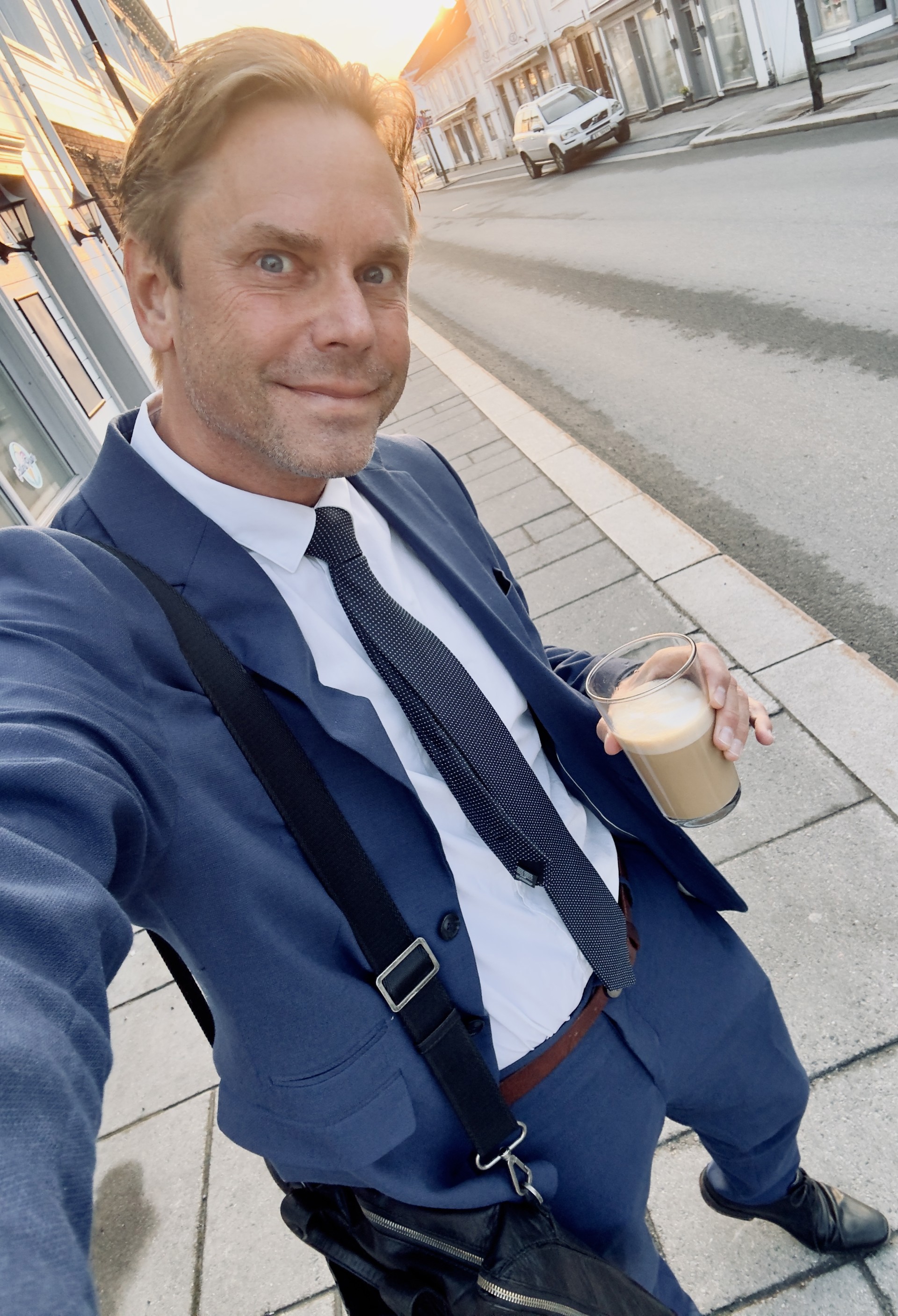 Selfie av Niclas i dress med kaffikopp