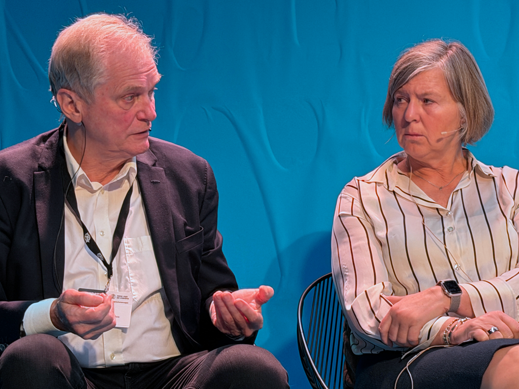 Bilde av Erik Fosse (t.v.) og Anne-Karin Rime (t.h.) De sitter foran en blå bakgrunn, og du ser dem fra livet og opp. Fosse prater. Han har grått og hvitt, kort hår, og sort dress med hvit skjorte inni. Rime ser på Fosse. Hun har lyst, kortklippet hår til nedforbi ørene, hvit skjorte med sorte striper og sitter med høyre hånd over venstre forarm. 