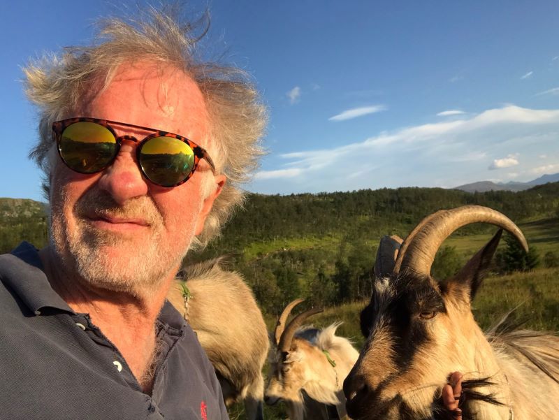 Bilde av Morten Sandbu med geiter i bakgrunnen. Foto: Privat