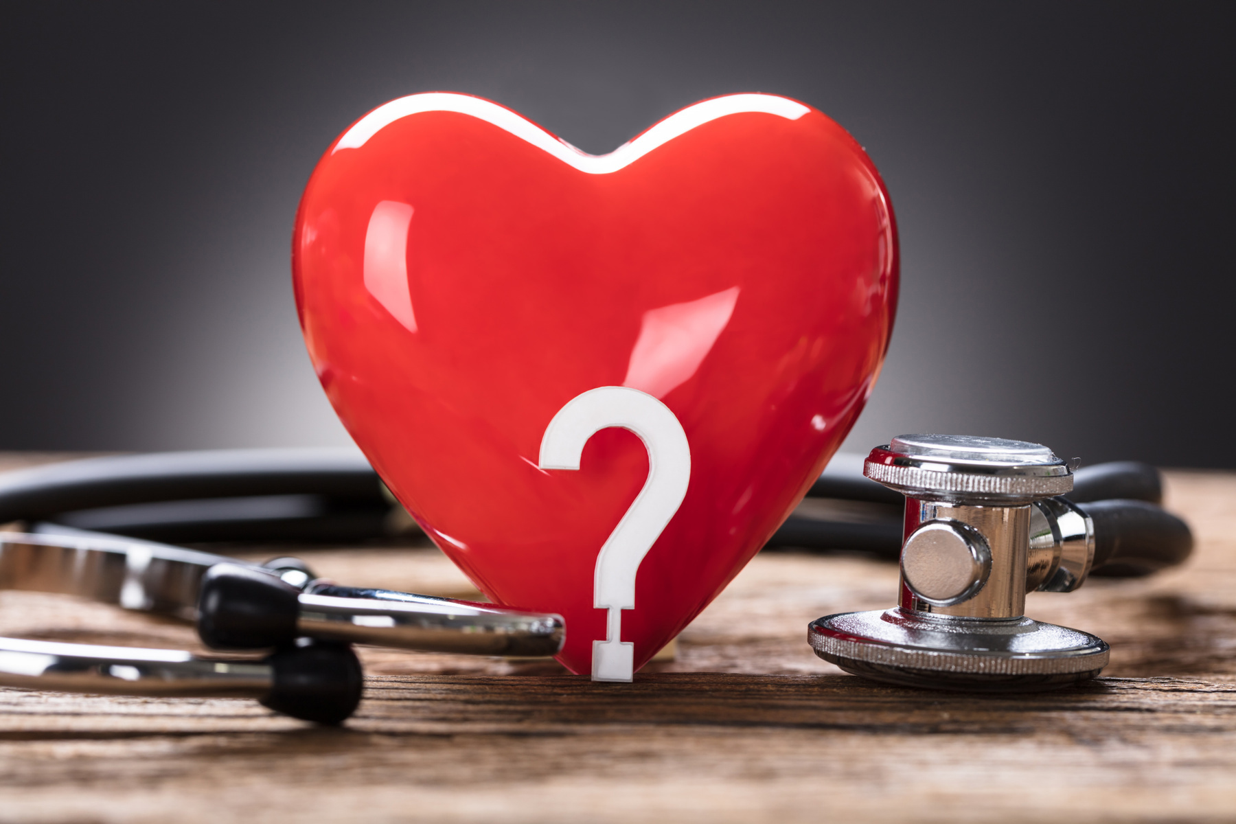 red-heart-and-question-mark-with-stethoscope-on-wood