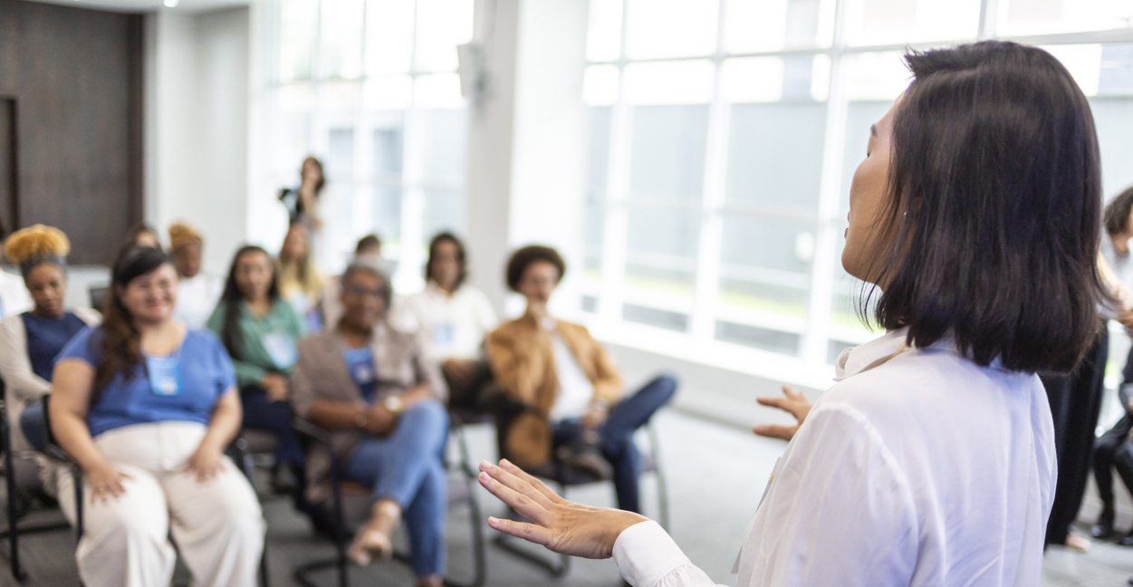En kvinne som holder en forelesning for en forsamling. Foto: Istockphoto.com/Anderson Coelho