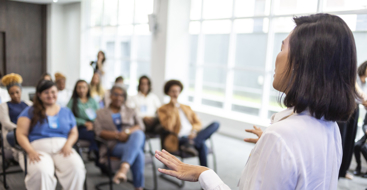 En kvinne som holder en forelesning for en forsamling. Foto: Istockphoto.com/Anderson Coelho