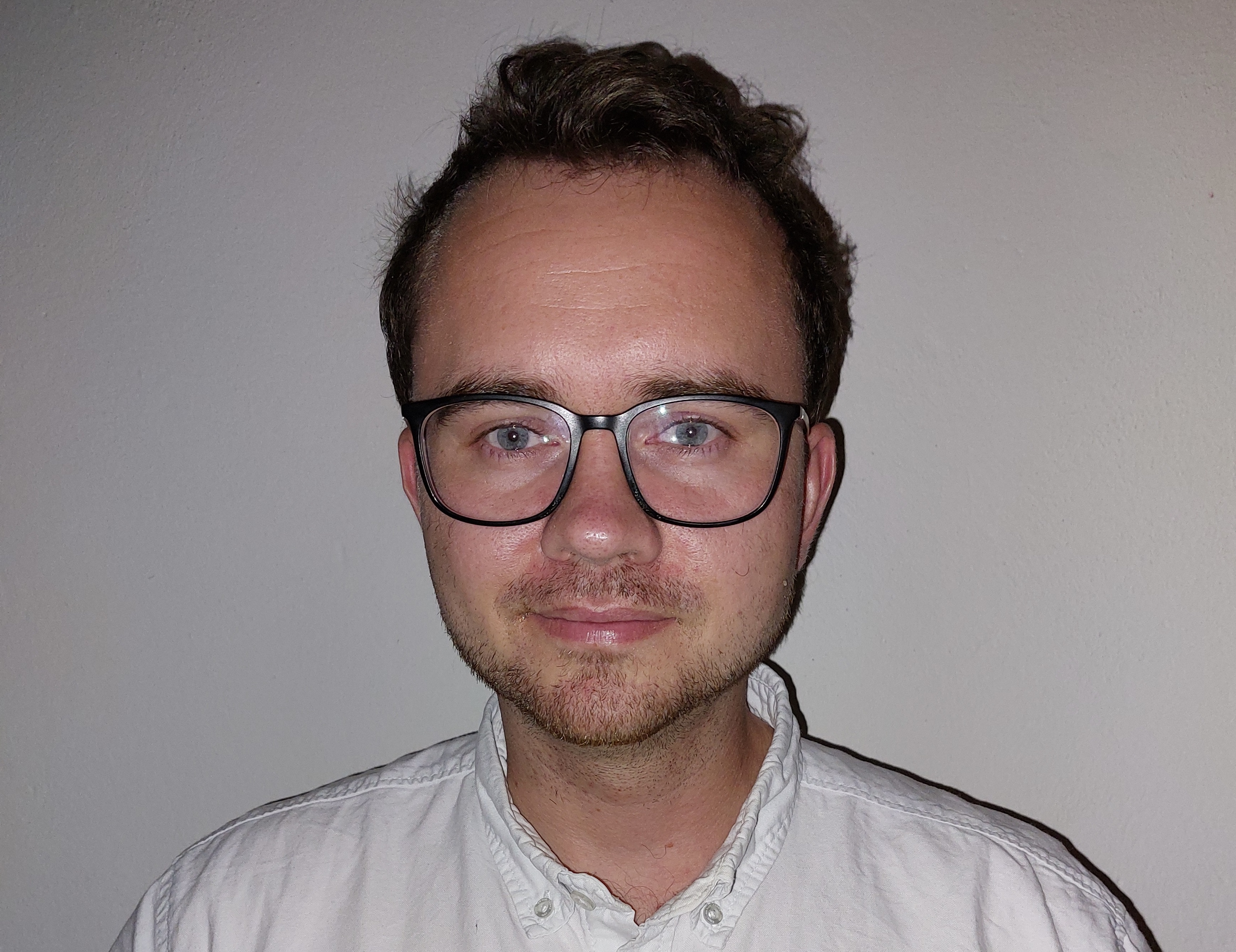 Bilde av en ung mann med briller.