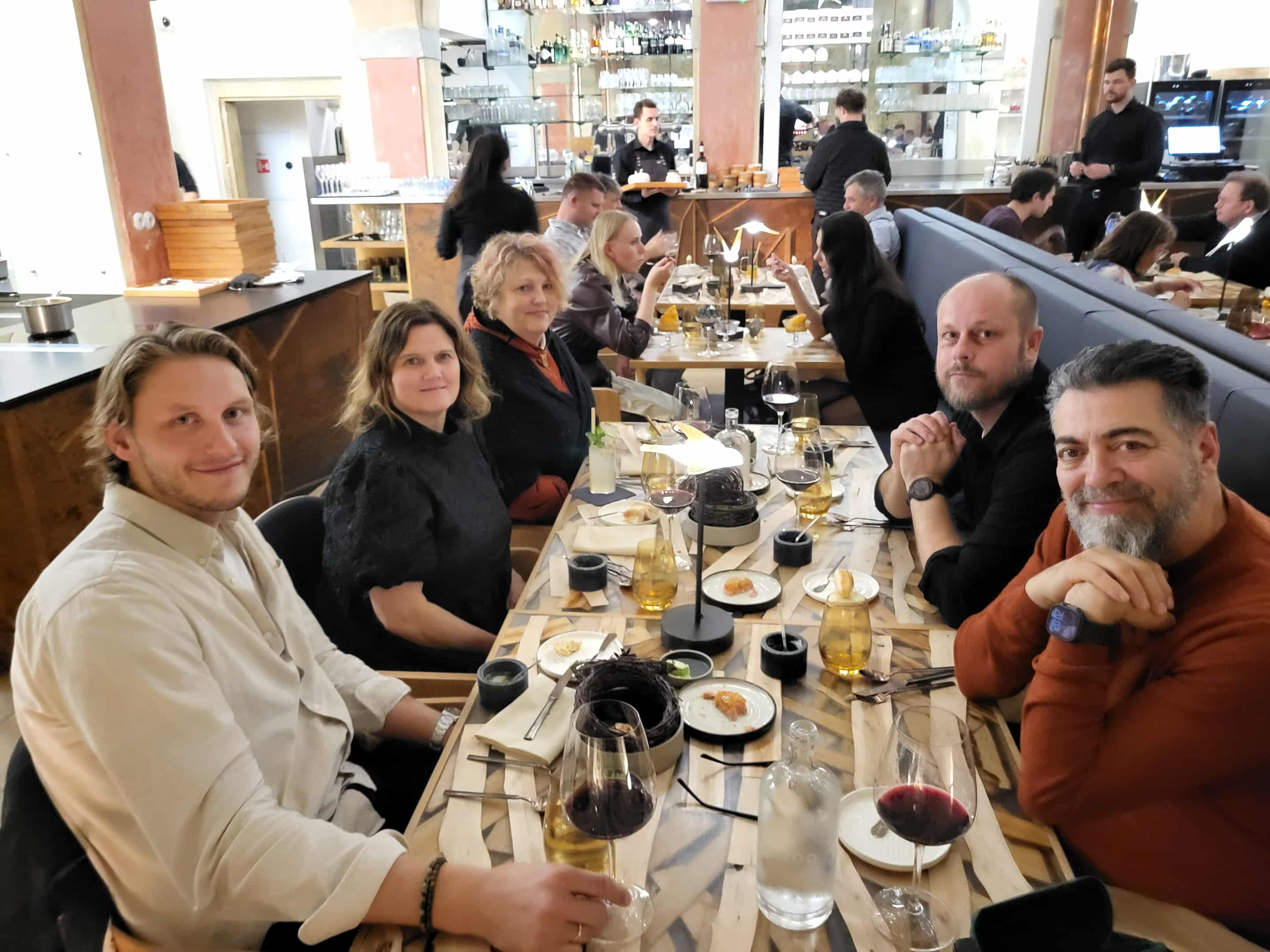 En gruppe mennesker som sitter rundt et bord p&aring; en restaurant.