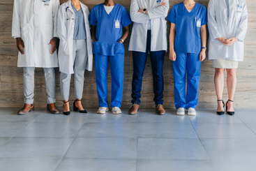 Helsepersonell på rad ved en vegg, hoder ikke synlig. Foto: Istockphoto.com/Moyo Studio